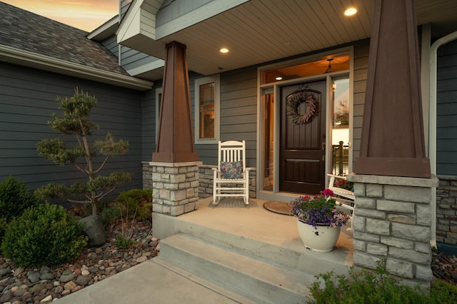 26042 Sunset Dr, Chisago City, MN 55013 - entrance to property with covered porch, a shingled roof, and stone siding