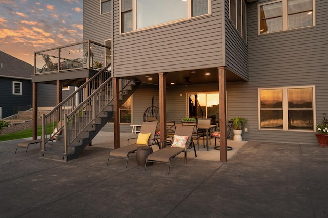26042 Sunset Dr, Chisago City, MN 55013 - patio terrace at dusk featuring a patio, stairway, and outdoor dining area