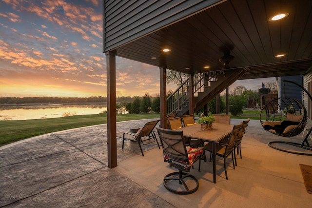 26042 Sunset Dr, Chisago City, MN 55013 - patio terrace at dusk featuring stairway, a patio, a water view, and outdoor dining area