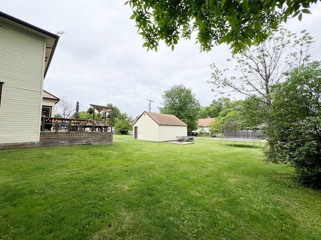 408 Lafayette Ave, Fulda, MN 56131 - view of green lawn featuring a trampoline, a wooden deck, and an outbuilding