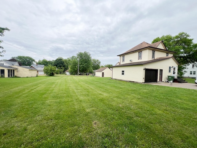 408 Lafayette Ave, Fulda, MN 56131 - view of grassy yard with a garage, concrete driveway, and a patio area