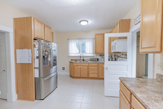 408 Lafayette Ave, Fulda, MN 56131 - kitchen with stainless steel fridge, light brown cabinets, a textured ceiling, a sink, and baseboards