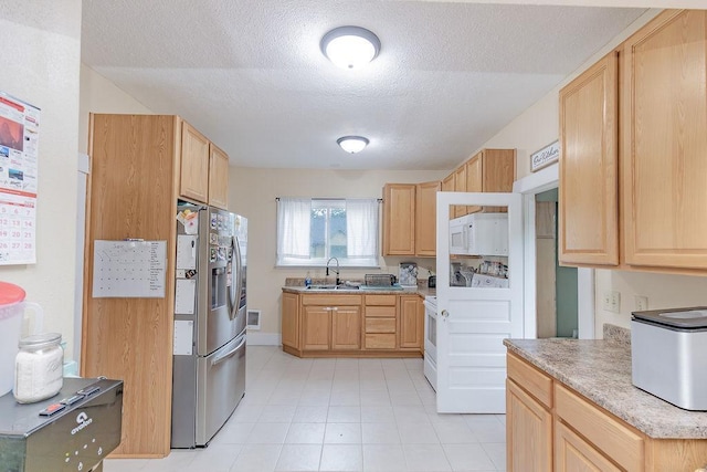408 Lafayette Ave, Fulda, MN 56131 - kitchen featuring stainless steel fridge with ice dispenser, light brown cabinetry, a textured ceiling, light countertops, and white microwave