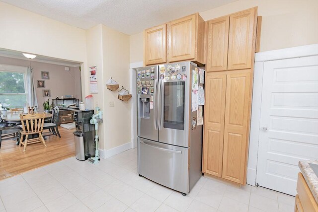 408 Lafayette Ave, Fulda, MN 56131 - kitchen featuring stainless steel refrigerator with ice dispenser, light brown cabinets, light countertops, a textured ceiling, and baseboards
