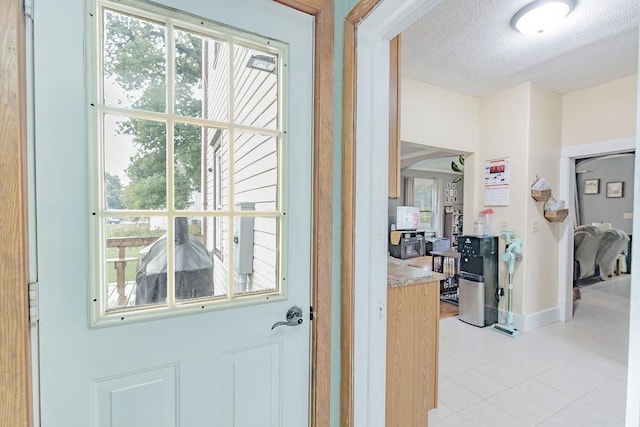 408 Lafayette Ave, Fulda, MN 56131 - entryway with light tile patterned flooring, a textured ceiling, and baseboards