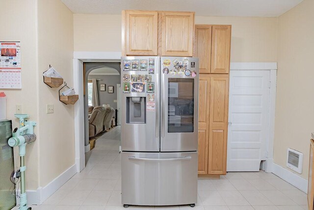 408 Lafayette Ave, Fulda, MN 56131 - kitchen with stainless steel fridge, light brown cabinetry, arched walkways, and baseboards