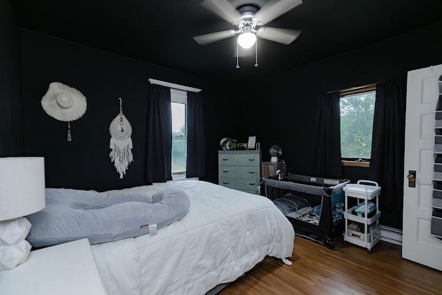 408 Lafayette Ave, Fulda, MN 56131 - bedroom with multiple windows, baseboard heating, wood finished floors, and ceiling fan