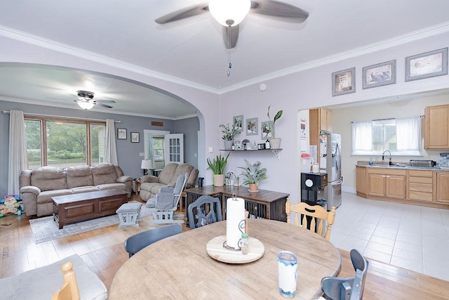 408 Lafayette Ave, Fulda, MN 56131 - dining space with ceiling fan, arched walkways, ornamental molding, and light wood-style flooring