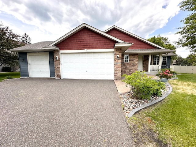 12224 Radisson Rd NE, Blaine, MN 55449 - craftsman house with stone siding, driveway, a garage, and covered porch