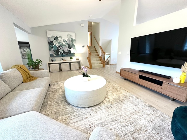 12224 Radisson Rd NE, Blaine, MN 55449 - living room with vaulted ceiling, wood finished floors, and stairs