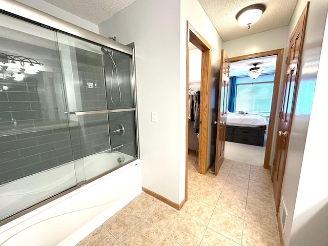 12224 Radisson Rd NE, Blaine, MN 55449 - bathroom with a textured ceiling, combined bath / shower with glass door, baseboards, ensuite bathroom, and tile patterned flooring