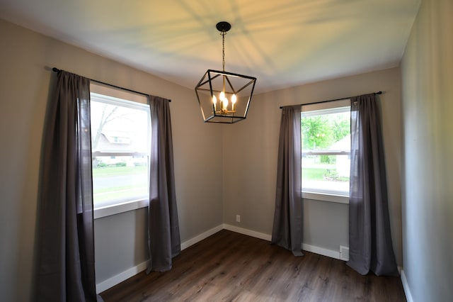 705 1st Ave SE, Pine Island, MN 55963 - spare room featuring a chandelier, baseboards, and dark wood-style floors