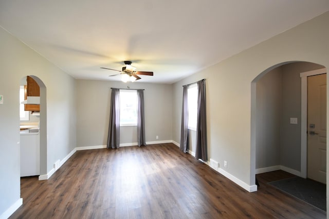 705 1st Ave SE, Pine Island, MN 55963 - empty room with arched walkways, a ceiling fan, washer / clothes dryer, dark wood-style flooring, and baseboards