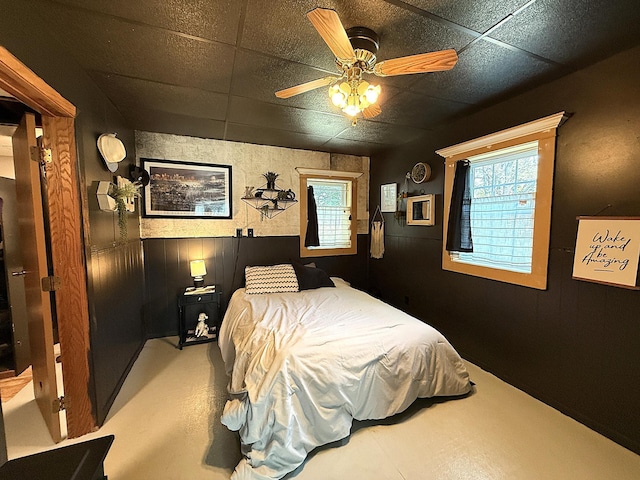 206 Oscar Ave N, Canby, MN 56220 - bedroom with wood walls, a ceiling fan, and a paneled ceiling