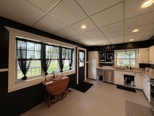 206 Oscar Ave N, Canby, MN 56220 - kitchen with stainless steel dishwasher, white cabinets, light countertops, recessed lighting, and freestanding refrigerator