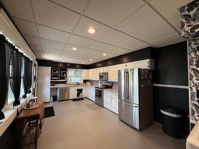 206 Oscar Ave N, Canby, MN 56220 - kitchen with stainless steel appliances, wainscoting, white cabinetry, a drop ceiling, and light countertops