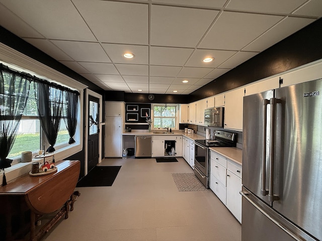 206 Oscar Ave N, Canby, MN 56220 - kitchen with appliances with stainless steel finishes, light countertops, white cabinets, a paneled ceiling, and recessed lighting