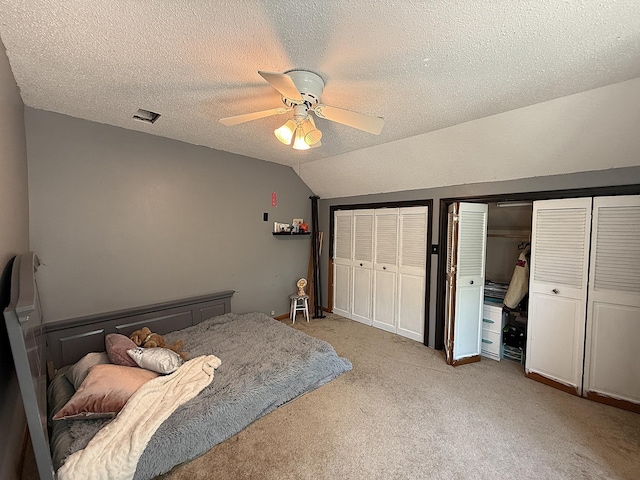 206 Oscar Ave N, Canby, MN 56220 - bedroom with multiple closets, vaulted ceiling, light carpet, a textured ceiling, and a ceiling fan