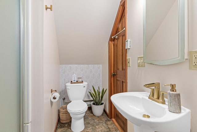 1391 Jefferson Ave, Saint Paul, MN 55105 - bathroom with a sink, toilet, vaulted ceiling, and stone finish flooring
