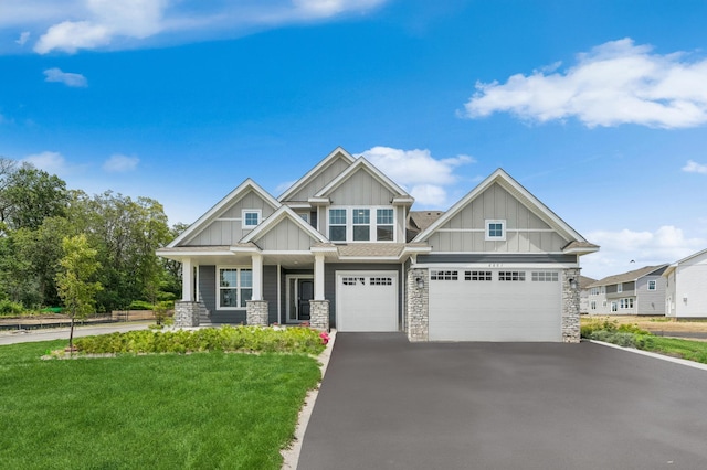 6601 Tamarack Ln, Corcoran, MN 55340 - craftsman inspired home with board and batten siding, stone siding, a front lawn, driveway, and a porch