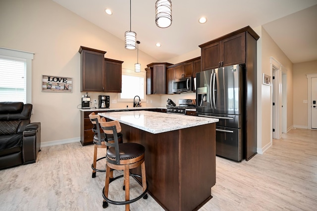 1160 21st St, Wabasha, MN 55981 - kitchen featuring stainless steel appliances, dark brown cabinets, a sink, light wood-type flooring, and vaulted ceiling
