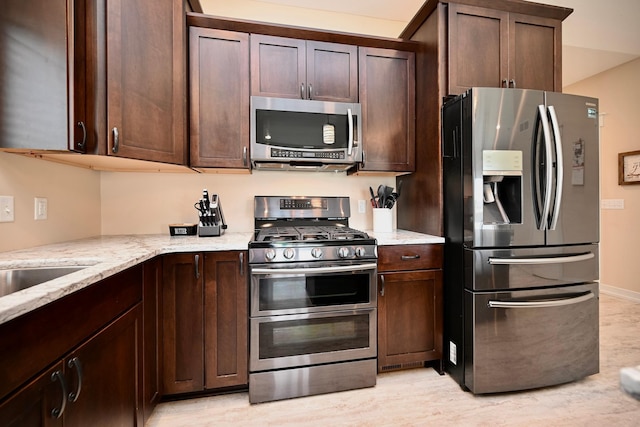 1160 21st St, Wabasha, MN 55981 - kitchen with appliances with stainless steel finishes, light stone counters, and dark brown cabinetry