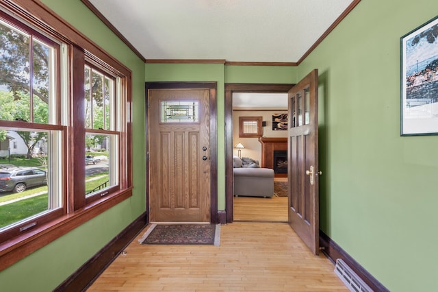 5136 16th Ave S, Minneapolis, MN 55417 - entrance foyer featuring light wood-style flooring, ornamental molding, a fireplace, and baseboards