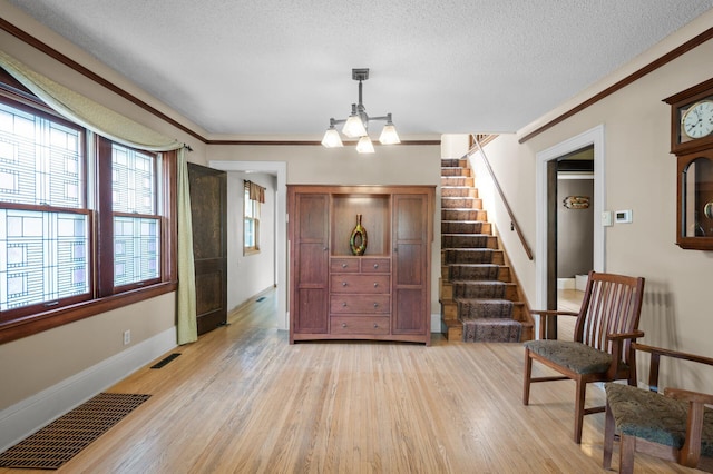 5136 16th Ave S, Minneapolis, MN 55417 - entrance foyer featuring stairs, light wood-type flooring, a chandelier, ornamental molding, and a textured ceiling