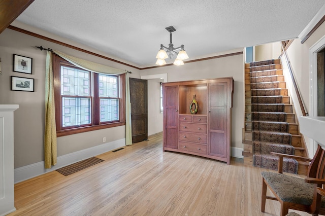 5136 16th Ave S, Minneapolis, MN 55417 - living area featuring light wood-style floors, stairway, a textured ceiling, a chandelier, and ornamental molding