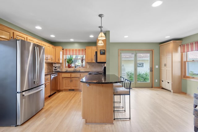 5136 16th Ave S, Minneapolis, MN 55417 - kitchen with appliances with stainless steel finishes, recessed lighting, a peninsula, a breakfast bar, and light wood-style floors