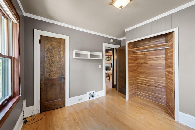 5136 16th Ave S, Minneapolis, MN 55417 - unfurnished bedroom with wood finished floors, crown molding, baseboards, wood walls, and a closet