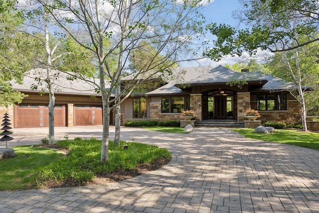 370 Ferndale Rd W, Wayzata, MN 55391 - view of front facade with curved driveway, stone siding, and a garage