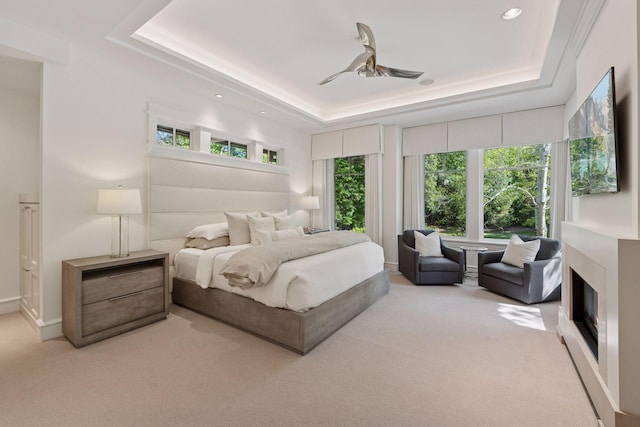 370 Ferndale Rd W, Wayzata, MN 55391 - bedroom featuring a raised ceiling, multiple windows, carpet floors, recessed lighting, and a glass covered fireplace
