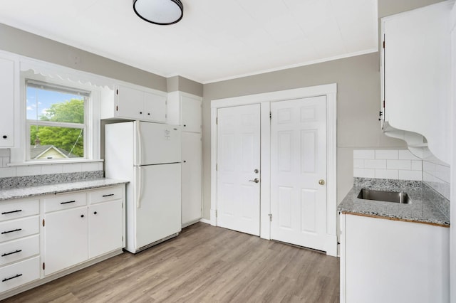 857 Oakdale Ave, Saint Paul, MN 55107 - kitchen featuring freestanding refrigerator, tasteful backsplash, light wood-style floors, white cabinetry, and crown molding