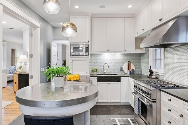 1929 Humboldt Ave S, Minneapolis, MN 55403 - kitchen with under cabinet range hood, stainless steel appliances, a sink, white cabinets, and crown molding