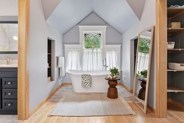 1929 Humboldt Ave S, Minneapolis, MN 55403 - full bathroom with vanity, a freestanding bath, wood finished floors, and lofted ceiling