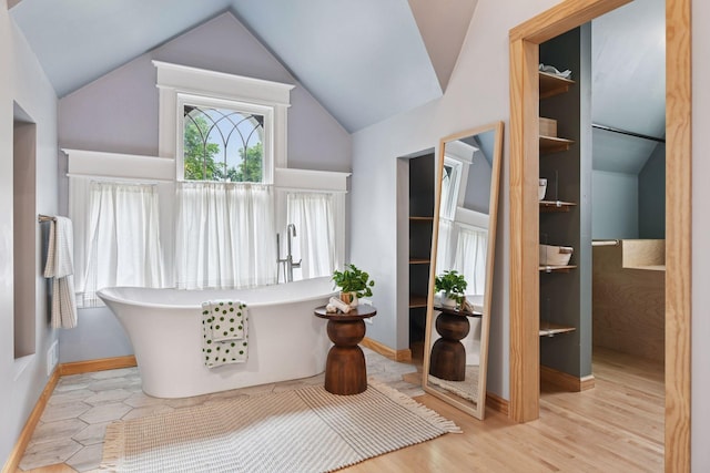 1929 Humboldt Ave S, Minneapolis, MN 55403 - bathroom with a soaking tub, lofted ceiling, wood finished floors, and baseboards