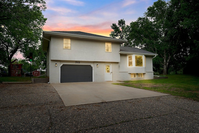 713 9th St NW, Buffalo, MN 55313 - tri-level home with an attached garage, concrete driveway, a front yard, stucco siding, and brick siding