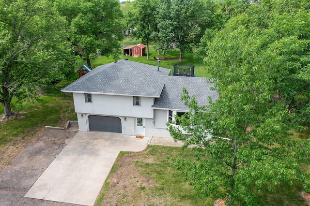 713 9th St NW, Buffalo, MN 55313 - view of front of house featuring an attached garage, a shingled roof, driveway, stucco siding, and a front lawn