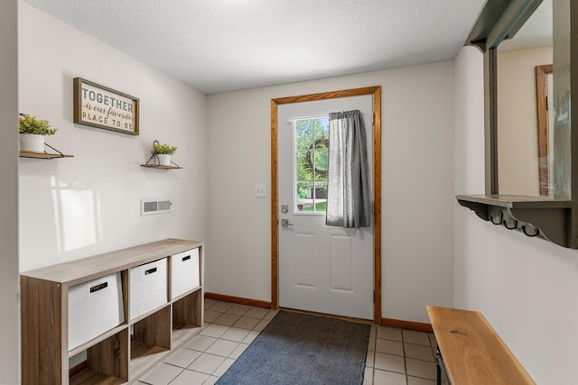 713 9th St NW, Buffalo, MN 55313 - entryway with light tile patterned flooring, baseboards, and a textured ceiling