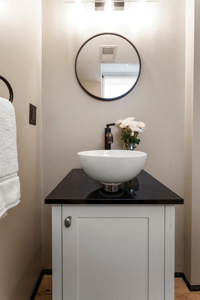 713 9th St NW, Buffalo, MN 55313 - bathroom featuring vanity, wood finished floors, and baseboards