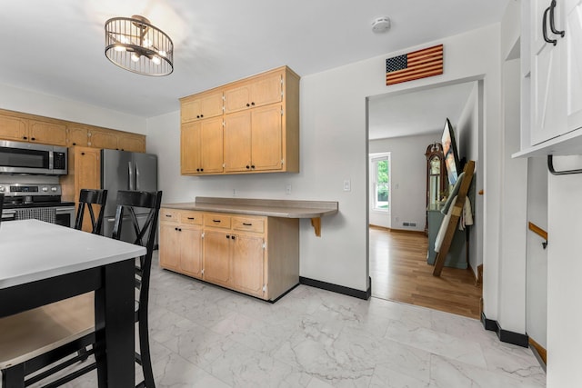 713 9th St NW, Buffalo, MN 55313 - kitchen featuring stainless steel appliances, light marble finish floors, baseboards, and light countertops