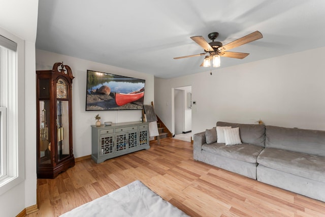 713 9th St NW, Buffalo, MN 55313 - living room featuring ceiling fan, wood finished floors, baseboards, and stairway