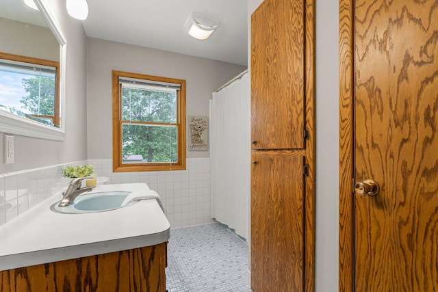 713 9th St NW, Buffalo, MN 55313 - bathroom featuring tile walls, a wainscoted wall, vanity, and a shower with curtain