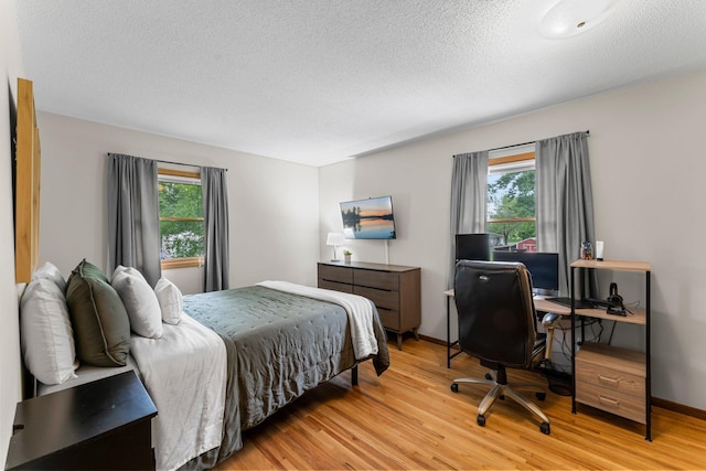 713 9th St NW, Buffalo, MN 55313 - bedroom with light wood finished floors, a textured ceiling, a desk, and baseboards