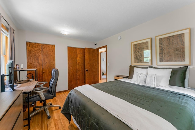 713 9th St NW, Buffalo, MN 55313 - bedroom with light wood-style floors, an office area, and two closets