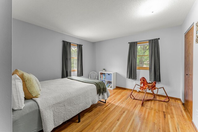 713 9th St NW, Buffalo, MN 55313 - bedroom with multiple windows, light wood finished floors, and baseboards