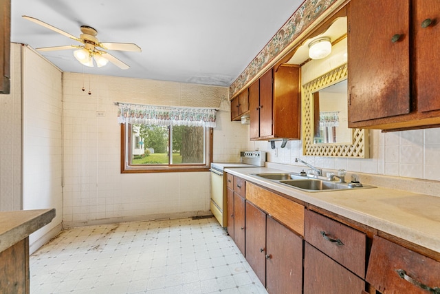 909 14th St S, Benson, MN 56215 - kitchen featuring white range with electric stovetop, a sink, light countertops, a ceiling fan, and brown cabinetry