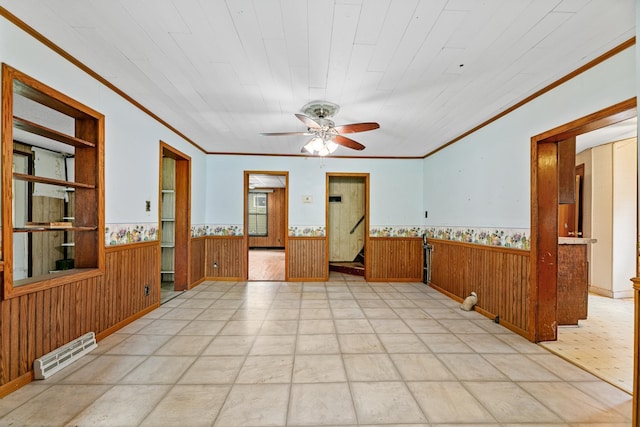 909 14th St S, Benson, MN 56215 - unfurnished room featuring wainscoting, crown molding, wood walls, and ceiling fan
