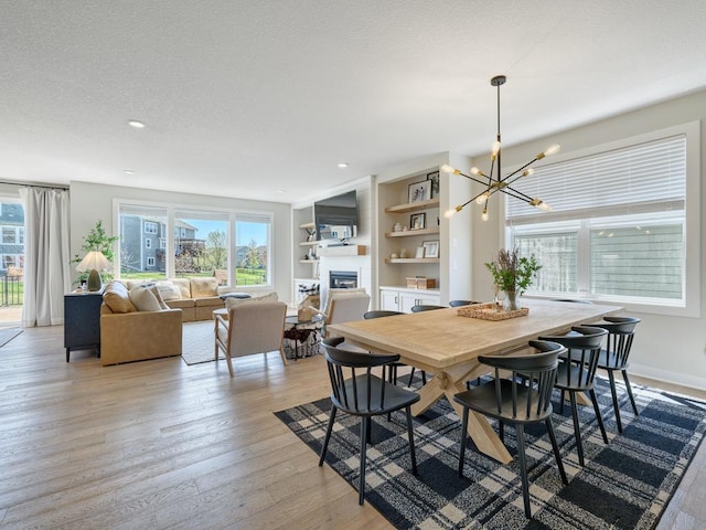 15441 110th Ave N, Dayton, MN 55369 - dining area featuring a glass covered fireplace, a chandelier, healthy amount of natural light, light wood finished floors, and recessed lighting